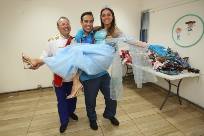 Dicesar e Tácito Cury seguram Maria Melilo no colo, vestida de Frozen